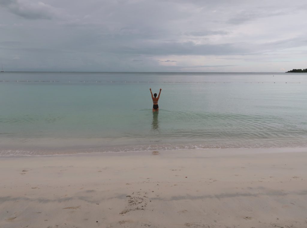 Jess Pendergrass in negril jamaica ocean with arms up