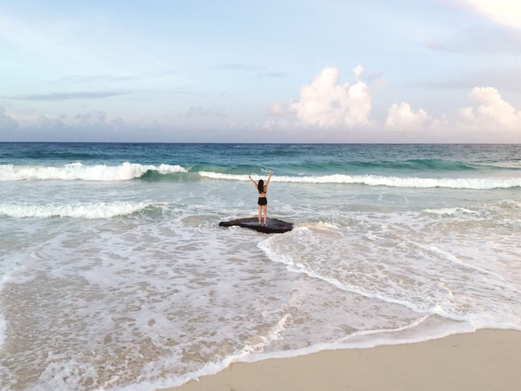 Jess Pendergrass on a rock in the ocean