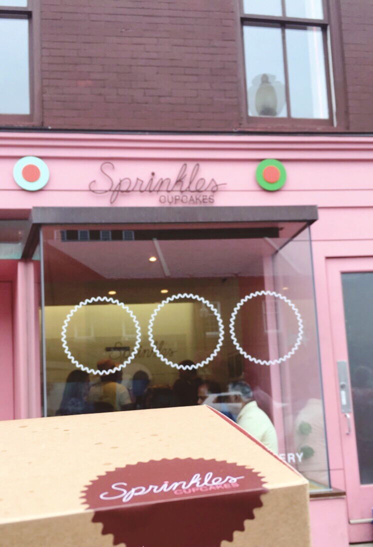 box of cupcakes outside pink Sprinkles Cupcakes storefront in Georgetown