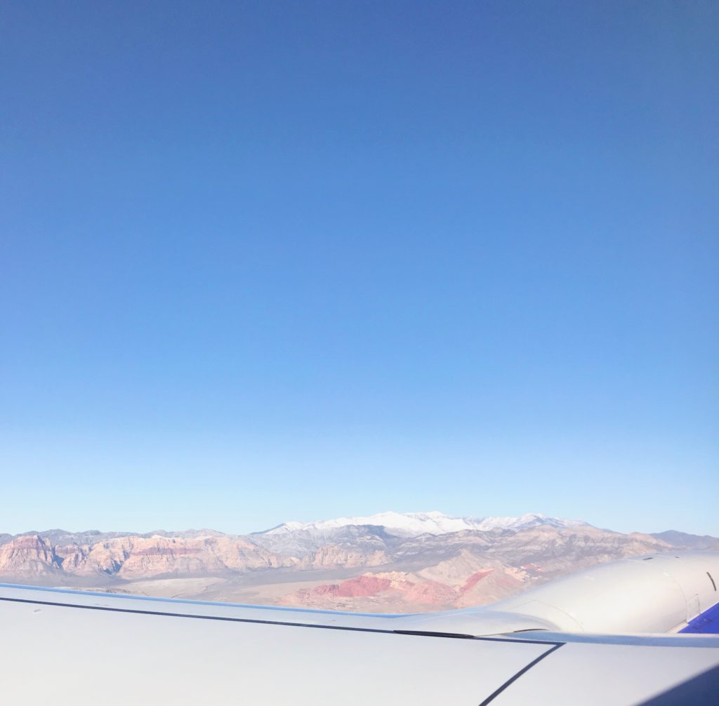 view from the plane: desert and mountains can be seen in the distance